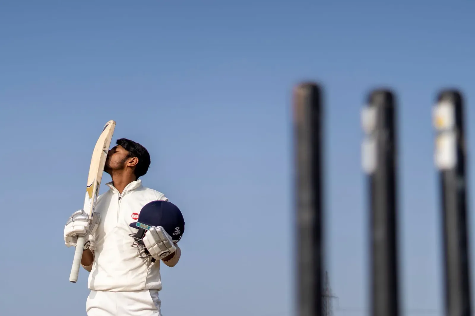 Jogador kriket Kamaljeet selebra sénturia ho nia kolega sira iha University of Jammu Cricket Ground