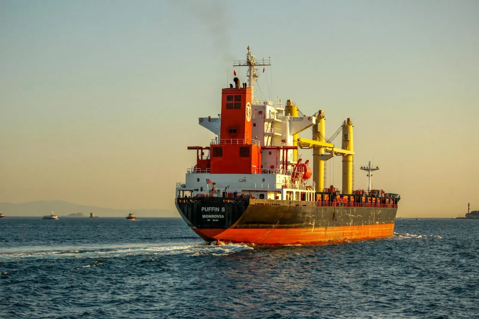 Kargu komersial boot iha tasi, ho avisu militar no mísseil Hellfire ne'ebé tiru ba sala mákina, iha Estreitu Hormuz