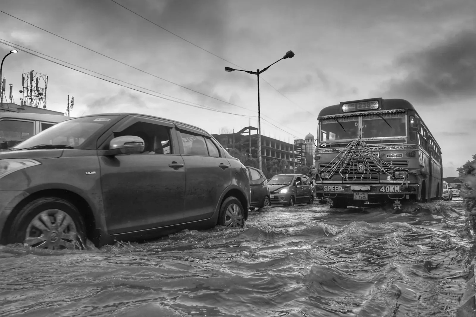 Imajen ida hatudu udan boot monsoonal iha sidade Mumbai, ho estrada nakonu no ema sira uza guarda-chuva, hanesan sinal mudans