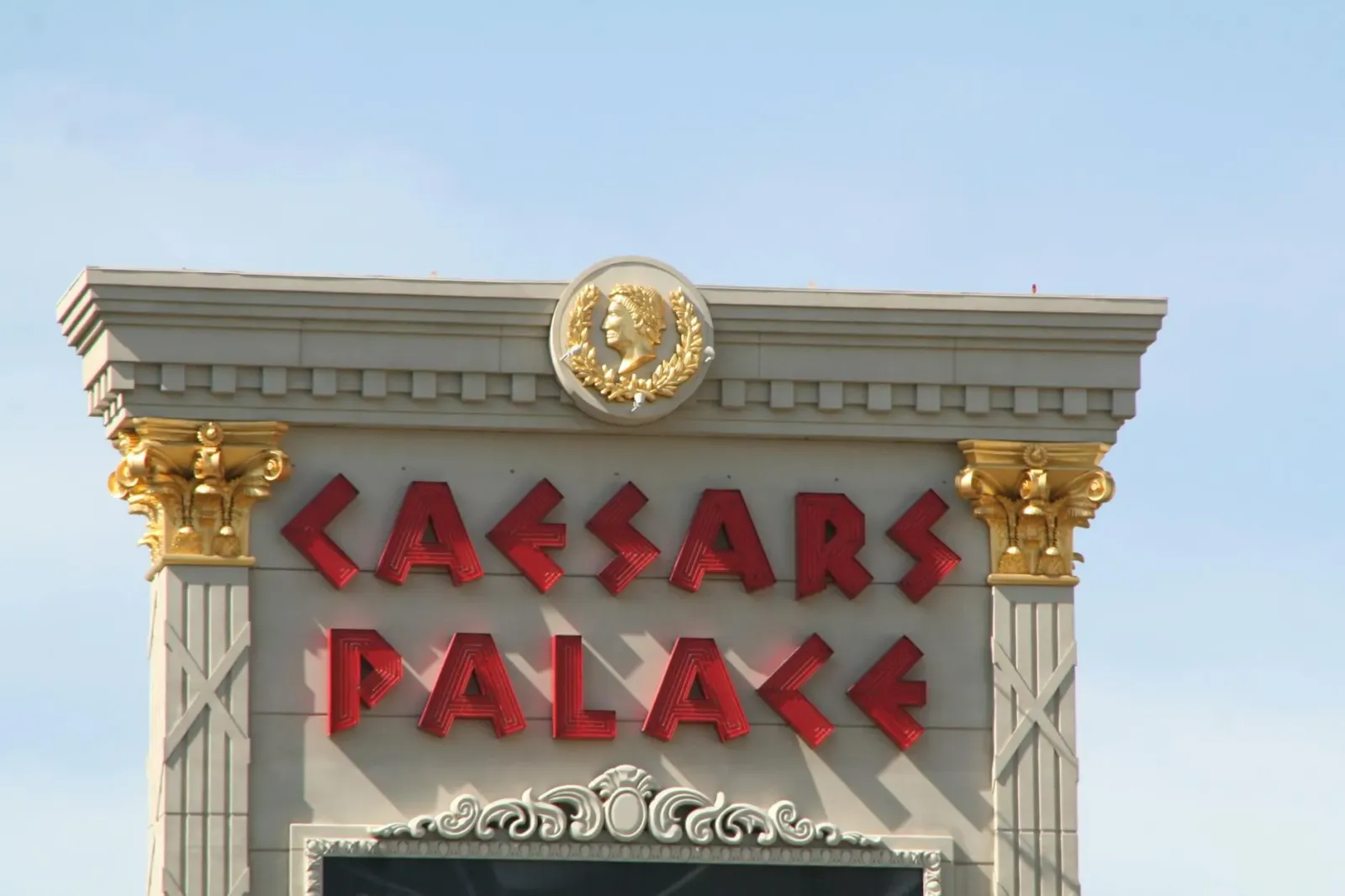 Imajen boot kona-ba Caesars Palace iha Las Vegas ho ema barak no luz neon, reprezenta konsolidasaun impériu entertenimentu no