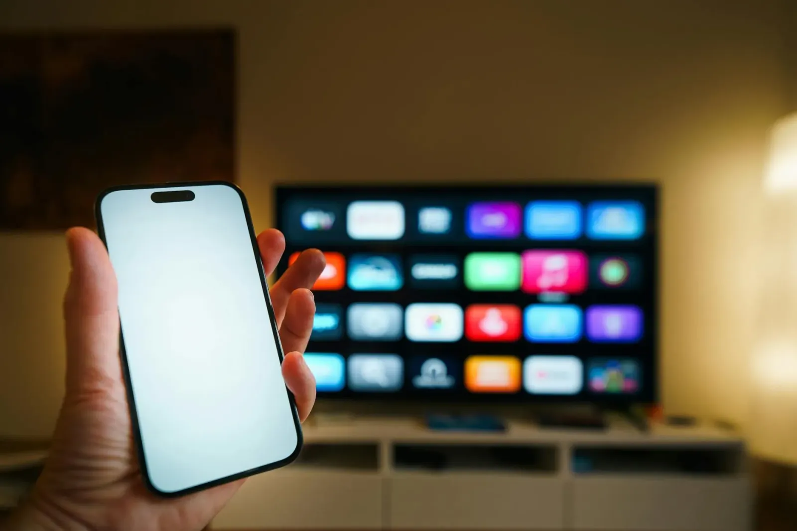 Imajen ida hatudu aparellu Roku ki'ik iha sala estár, ho kontrolu remotu iha meza, hanesan símbolu husi plataforma streaming 