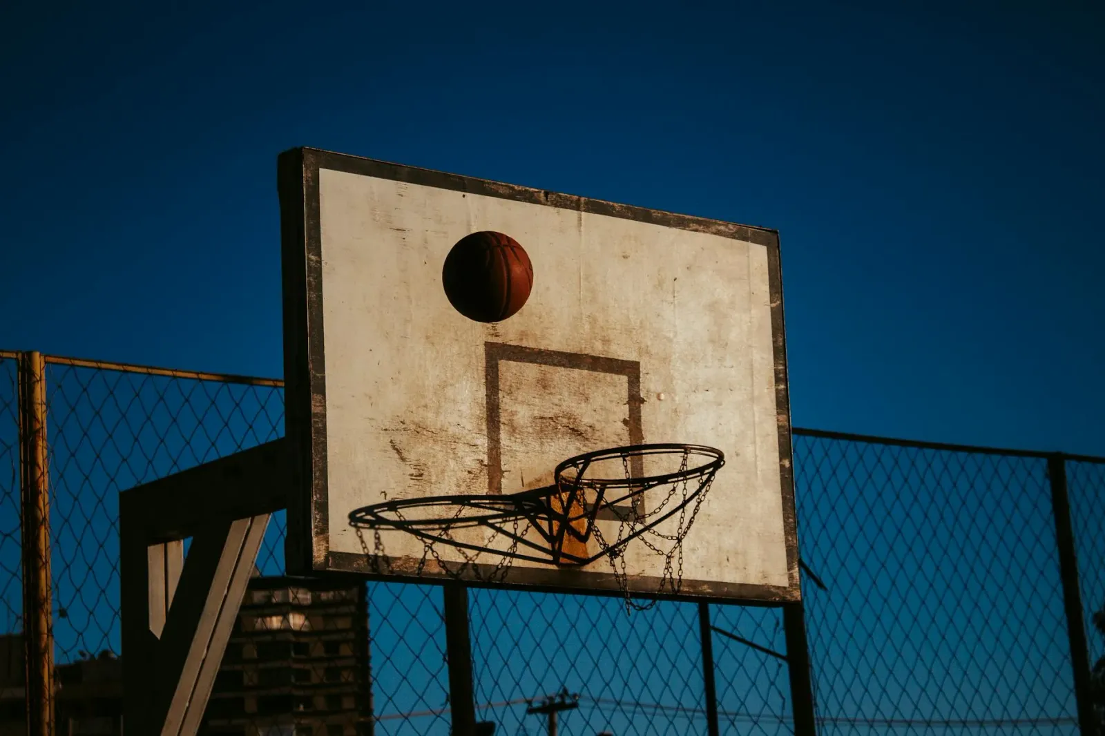 Imajen ida ne'ebé hatudu kancha basket ho livru apuesta no osan, simboliza subornu no korrupsaun iha desportu, ho foku ba int