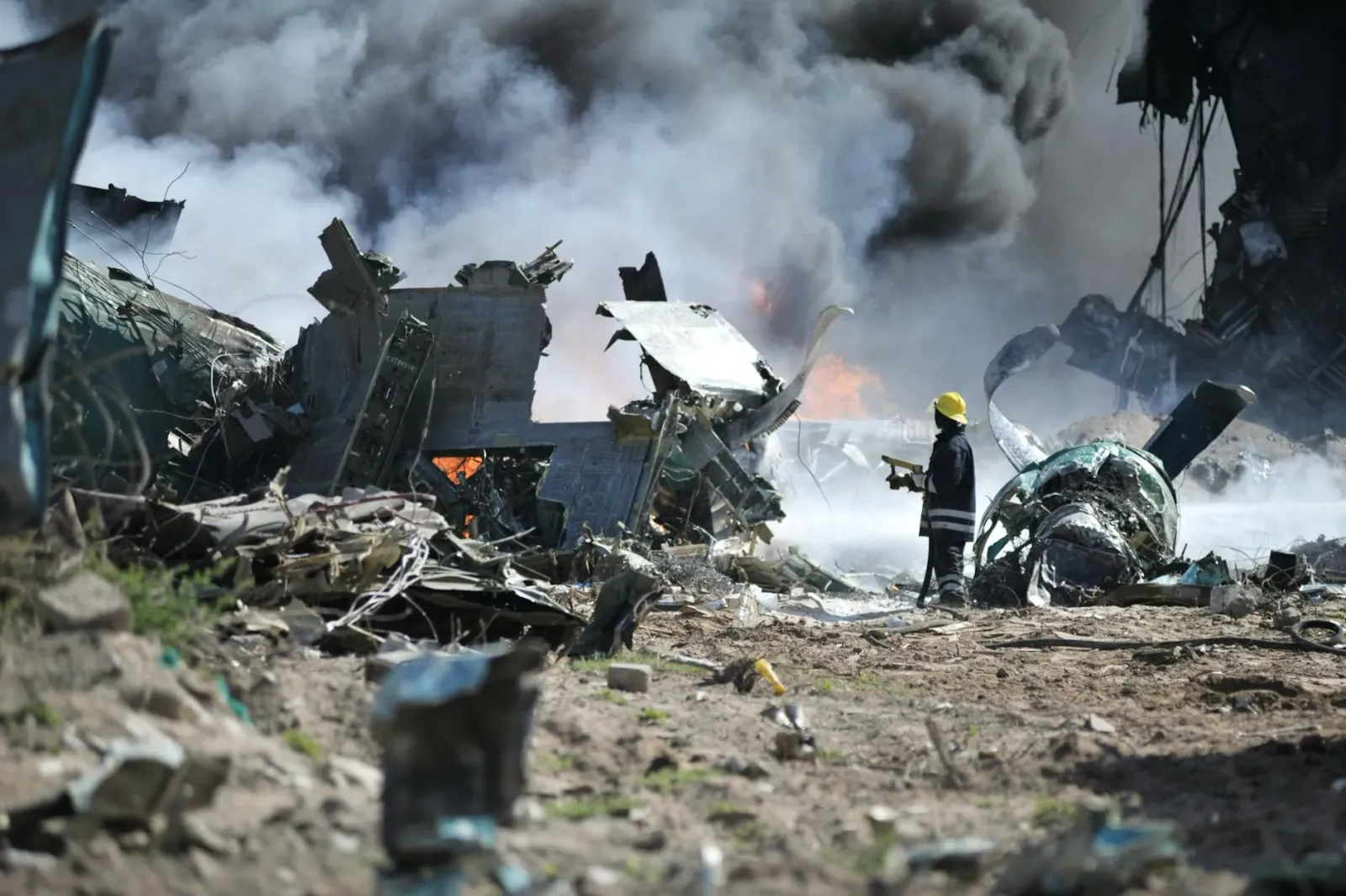 Imajen husi area planta kimiku ne'ebé esplode, ho ema servisu sira hamriik iha fatin tragédia, hatudu risku husi falta regula