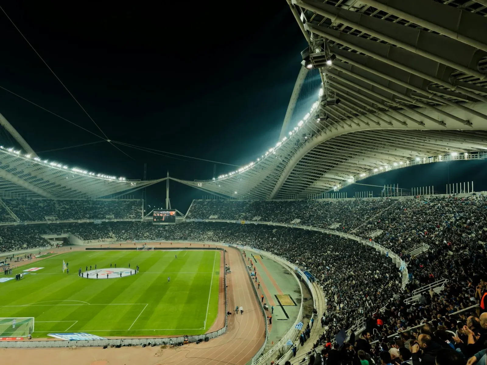 Ema barak iha estadiu desportu ho luzes no kamera, hatudu presaun boot ba atleta sira