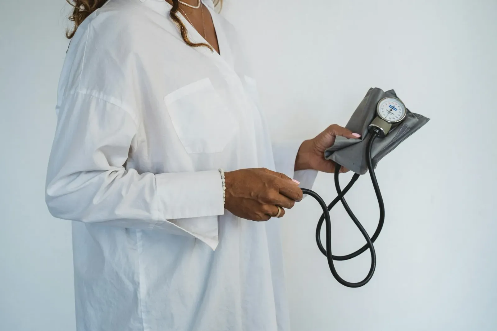 Smart ring Oura Ring 5 iha liman ema nian, hatudu teknolojia monitorizasaun saúde pessoál ho AI health coach, iha fundu azul 