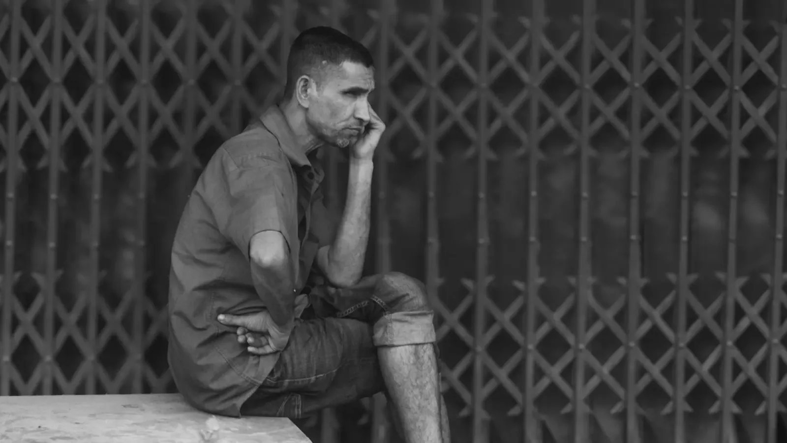 Ema ida tuur iha meja, hanoin kona-ba integridade no resiliénsia, ho notísia sira iha komputador