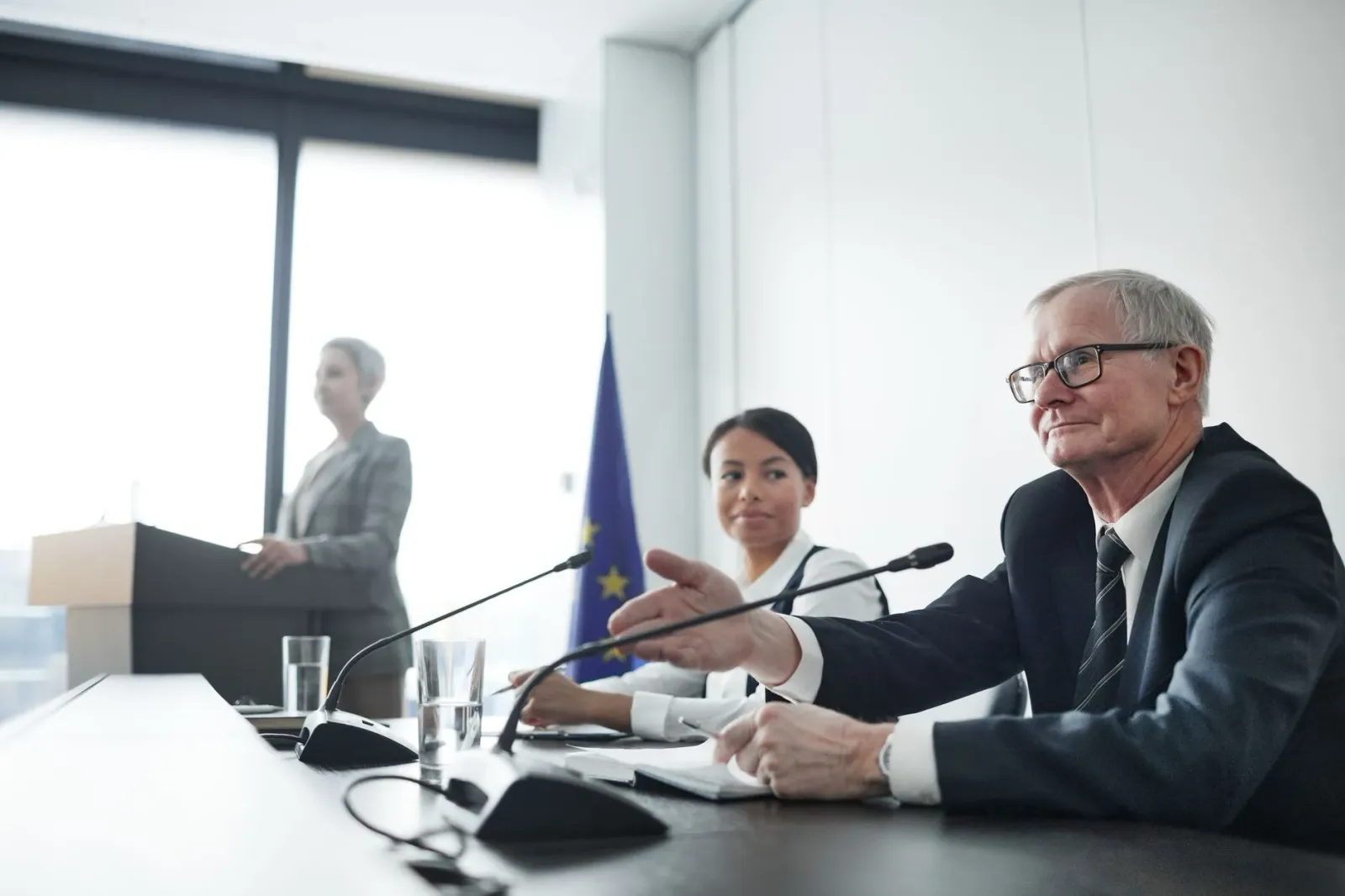 Grupu emprezariu sira tuur iha meja diskute risku polítika no incerteza lei, ho dokumentu no komputador iha meja