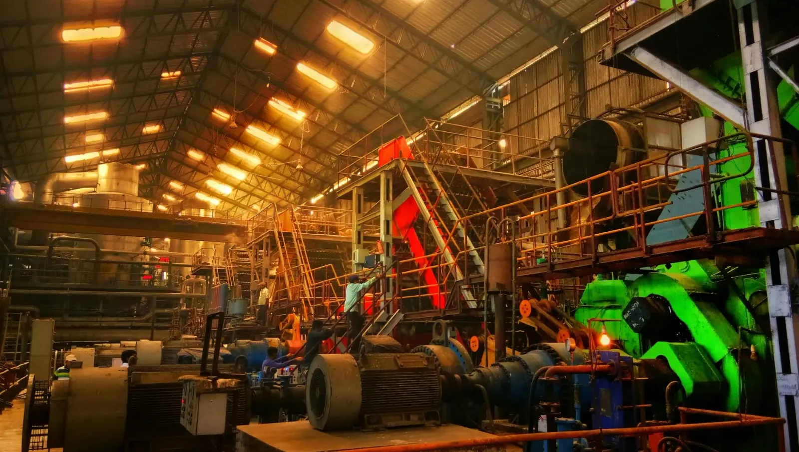 Fábrika manufatura iha India ho makina industrial no funsionáriu servisu hela, simboliza kresimentu produsaun industrial ne'e