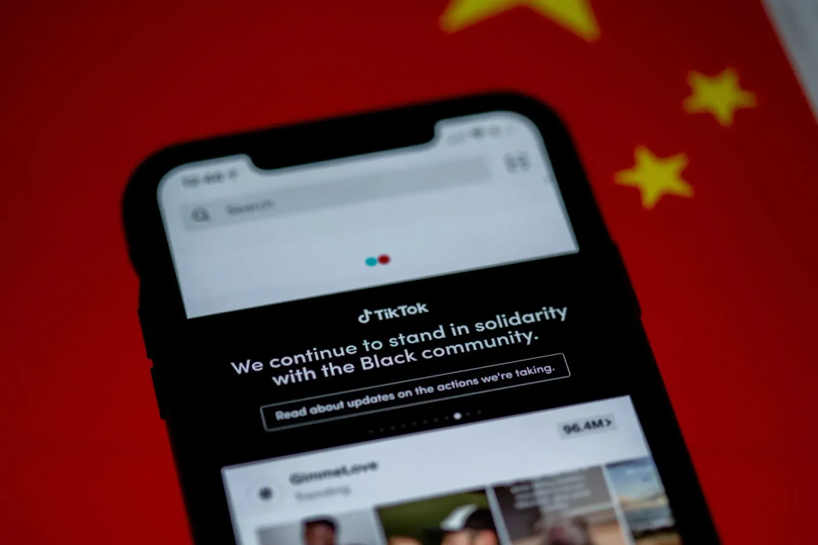 Smartphone hatudu TikTok logo no GB News nia vídeu, ho mundu iha fundu, atu hatudu atensaun global ba média sosial