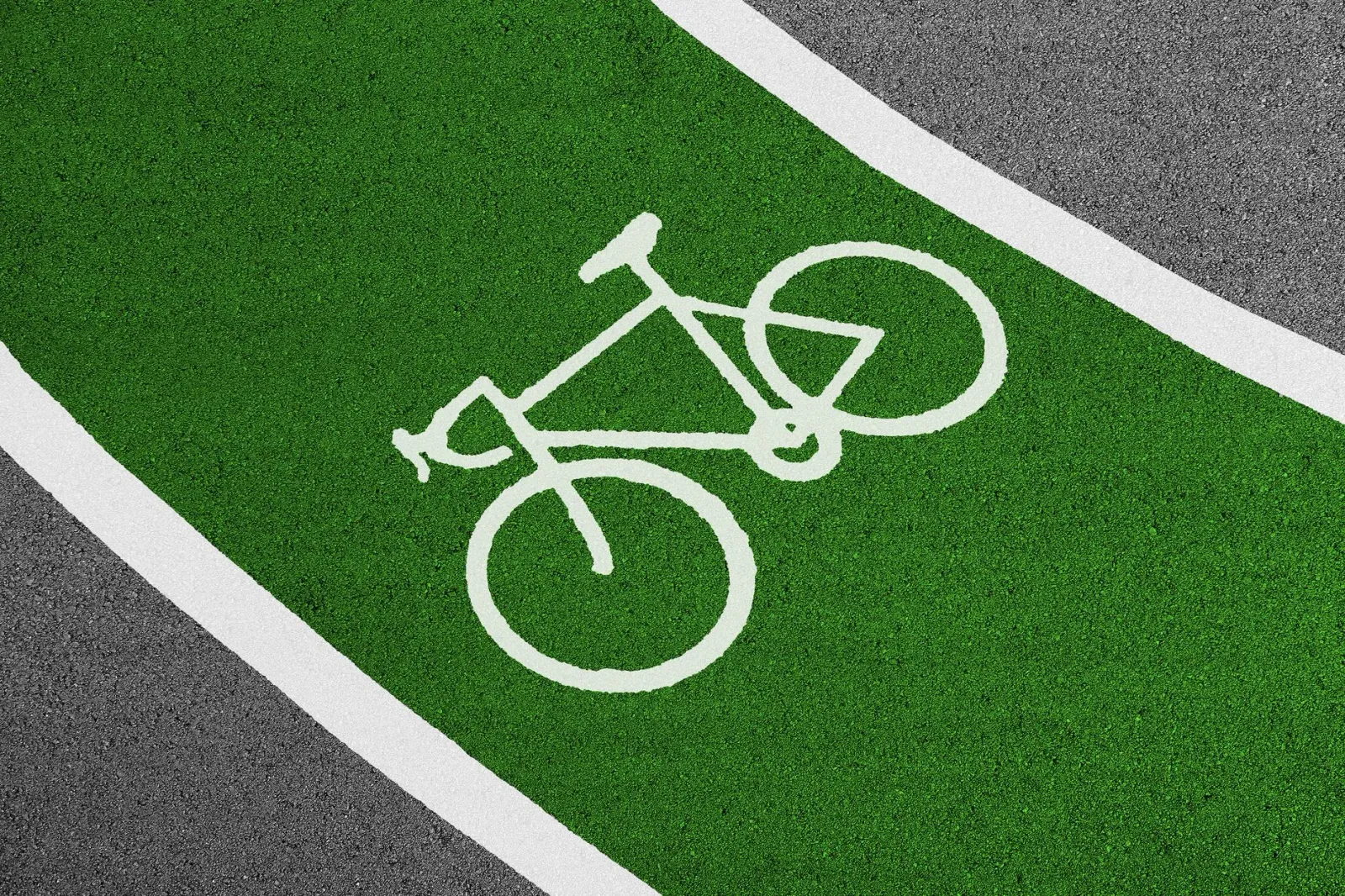 Imajen ida hatudu bike lane ne'ebé luan ki'ik liu fali símbolu siklu nian iha estrada urbana, ho siklista ida tenta uza lane 