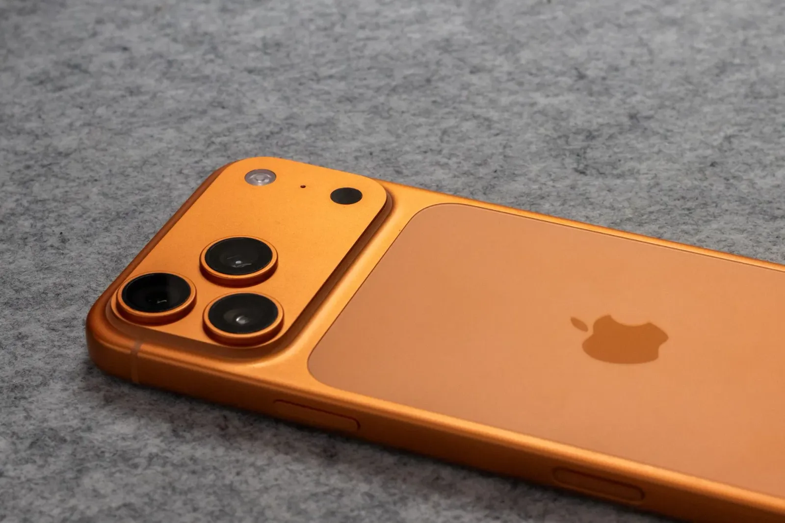 iPhone 18 Pro ho kór foun sira hanesan Deep Purple no Alpine Green, iha meja modernu ho luz neon, hatudu futuru teknolojia.