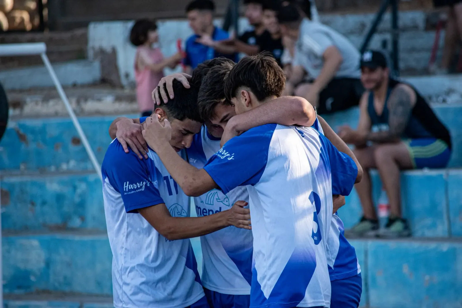 Imajen hatudu atleta mane na'in rua iha kampu desportu, sira haksoit no sorri, hatudu amizade forte no vulnerabilidade emosio