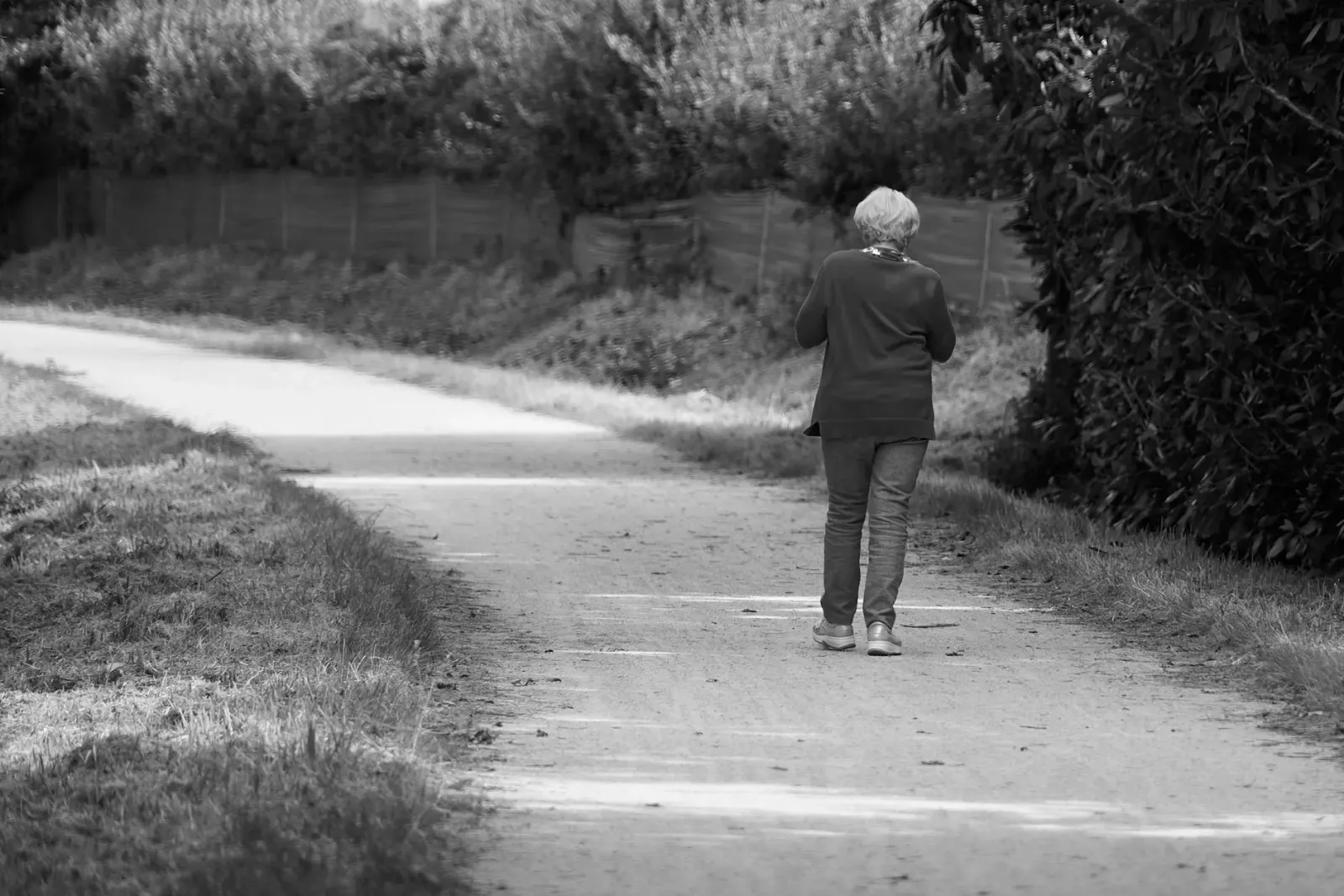 Ema idade médiu halo caminhada iha natureza, ho rosto sorrisu, hatudu oinsá movimentu isin ajuda atu atrasa idade no mantein 