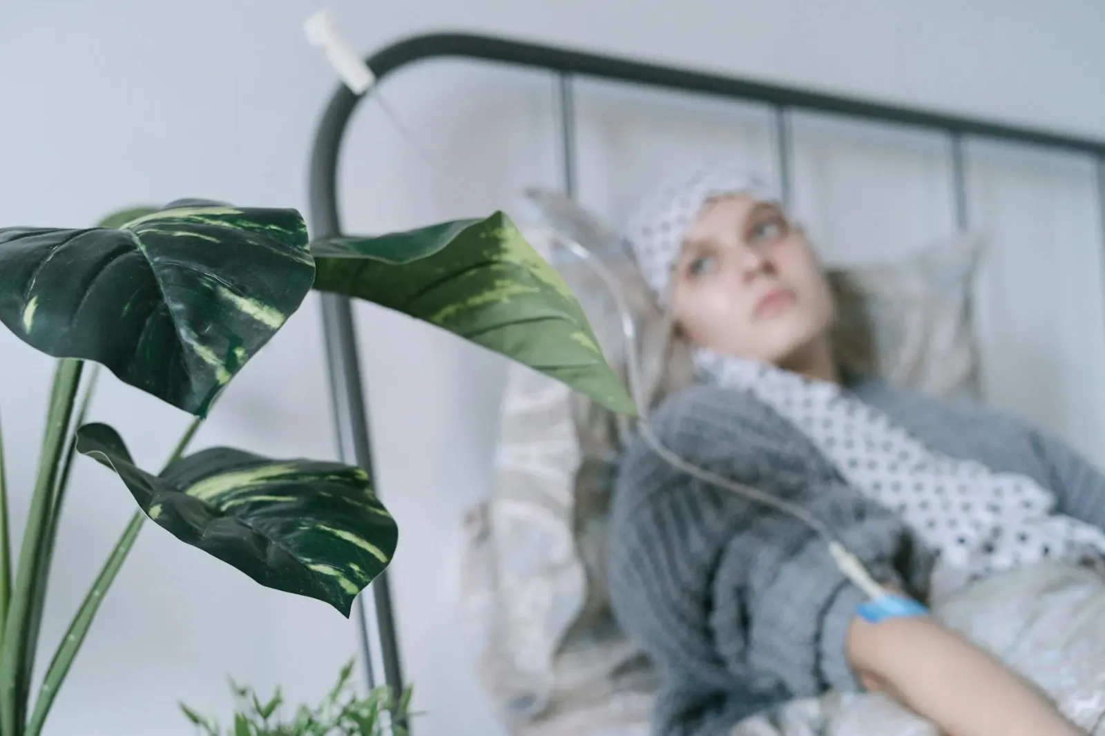 Pasiente kanser paru iha kama ospital ho esprasaun esperansa, iha janela ho luz naturale, hatudu forsa no reziliénsia durante