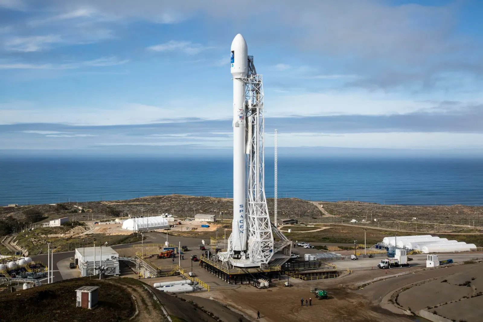 Imajen ida ne'e hatudu foguete SpaceX lansa hela iha loron, ho jogu portátil Lenovo Legion Go iha liman, no ema Yindjibarndi 