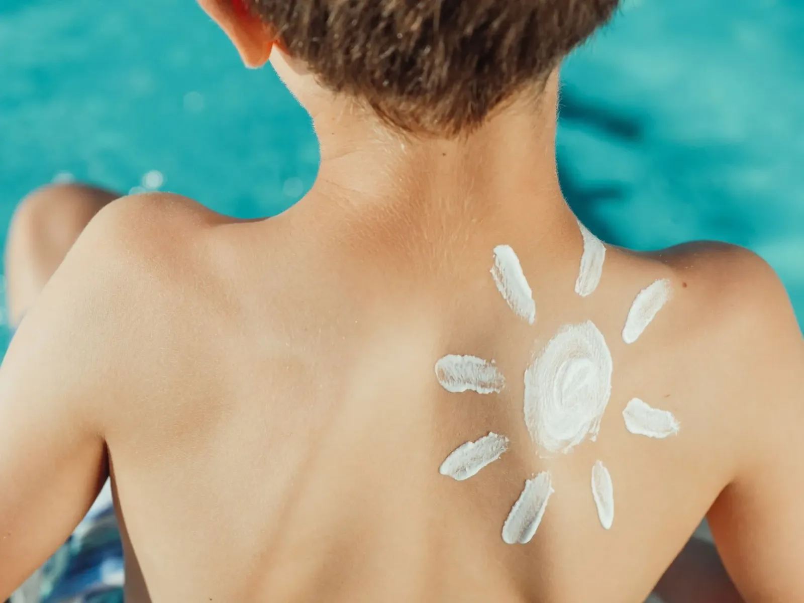 Imajen ida hatudu FDA nia selu no frasco sunscreen iha meja, ho fundu azul no dokumentu ofisial