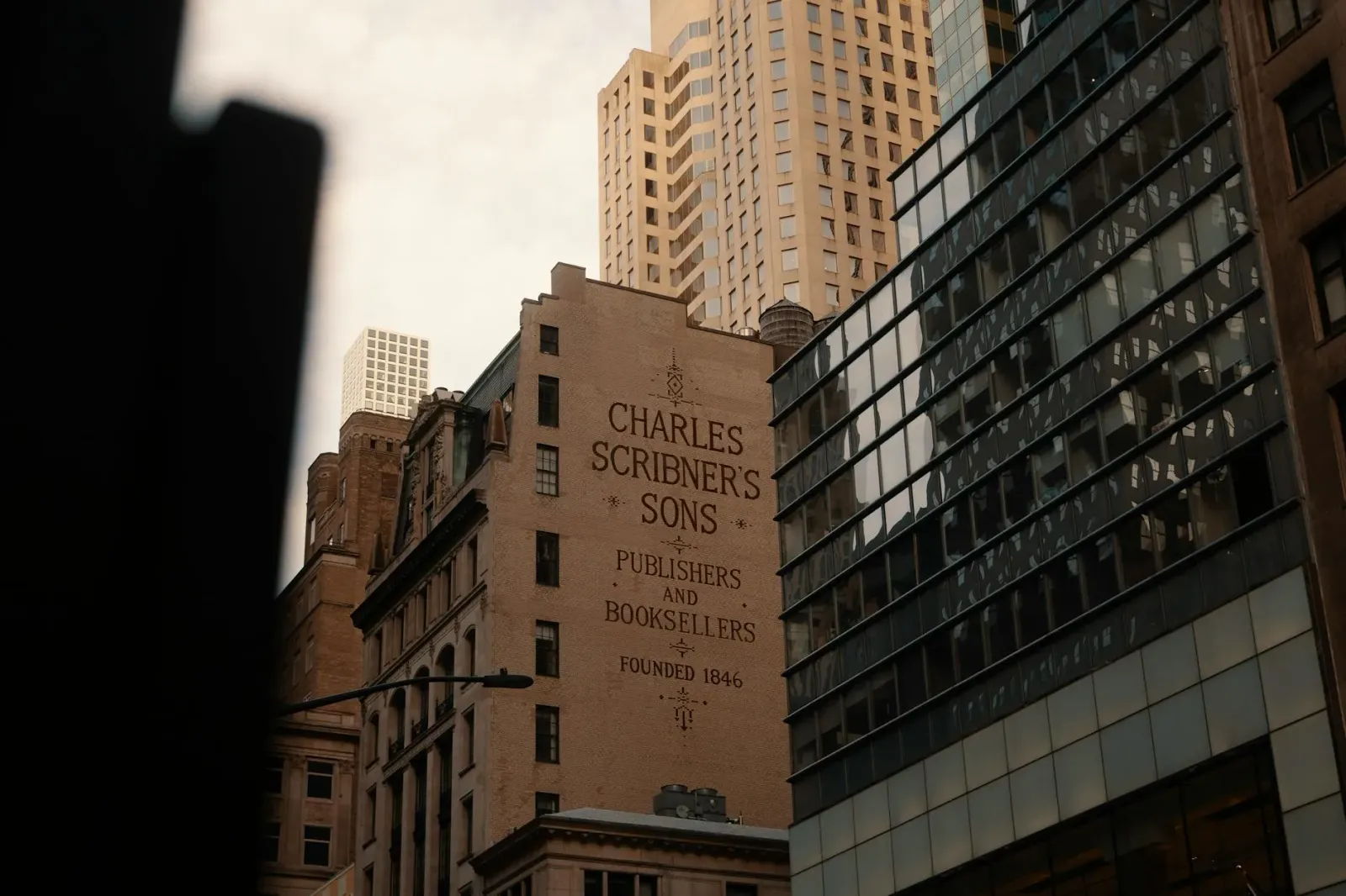 Imajen edifísiu CBS News iha Nova York ho logótipo '60 Minutes' no foto Scott Pelley no Bari Weiss iha fundu, hanesan ilustra