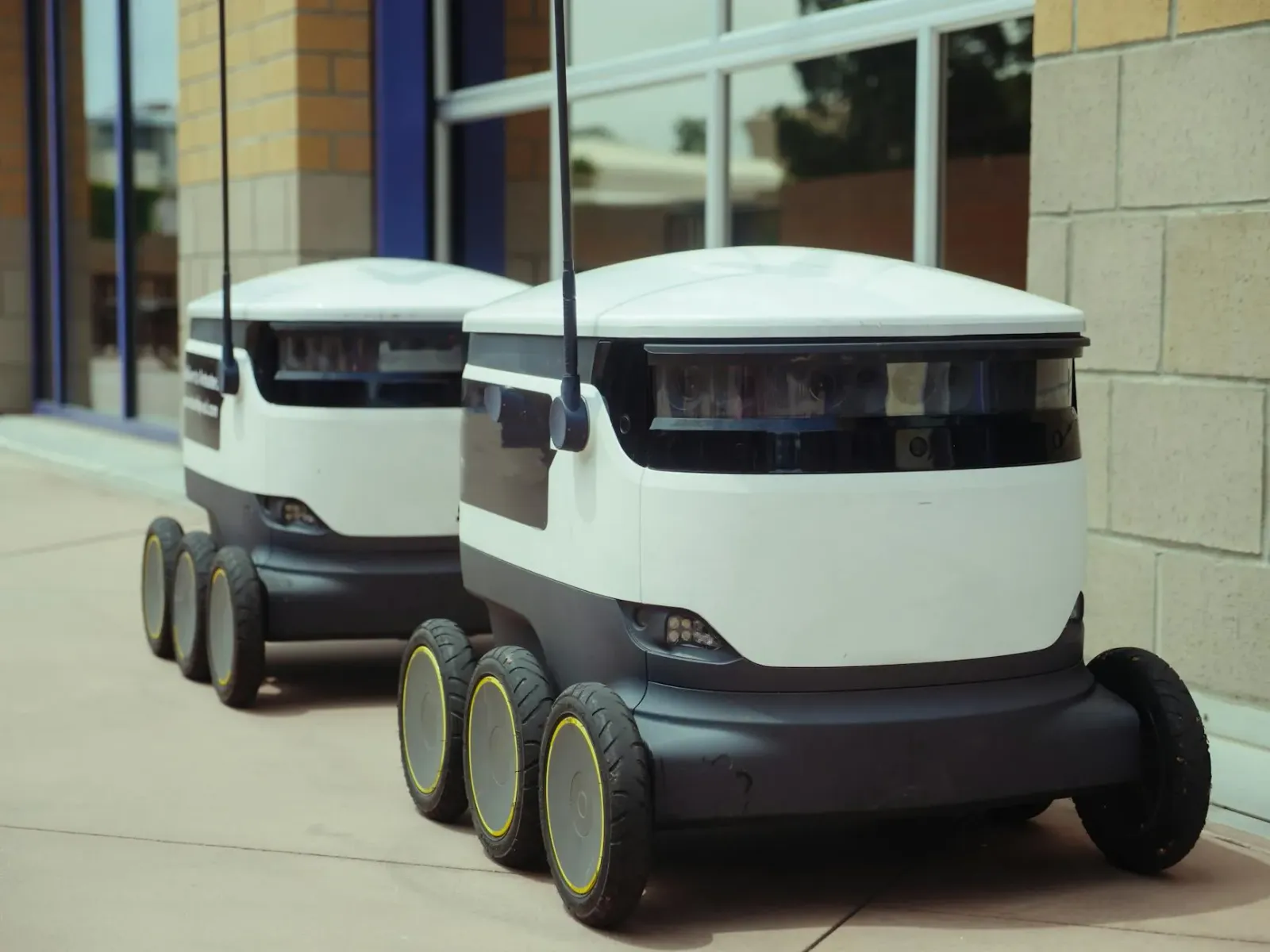 Robot AI autónomu servisu iha armazén logístika ho luz neon azul no sensór sira