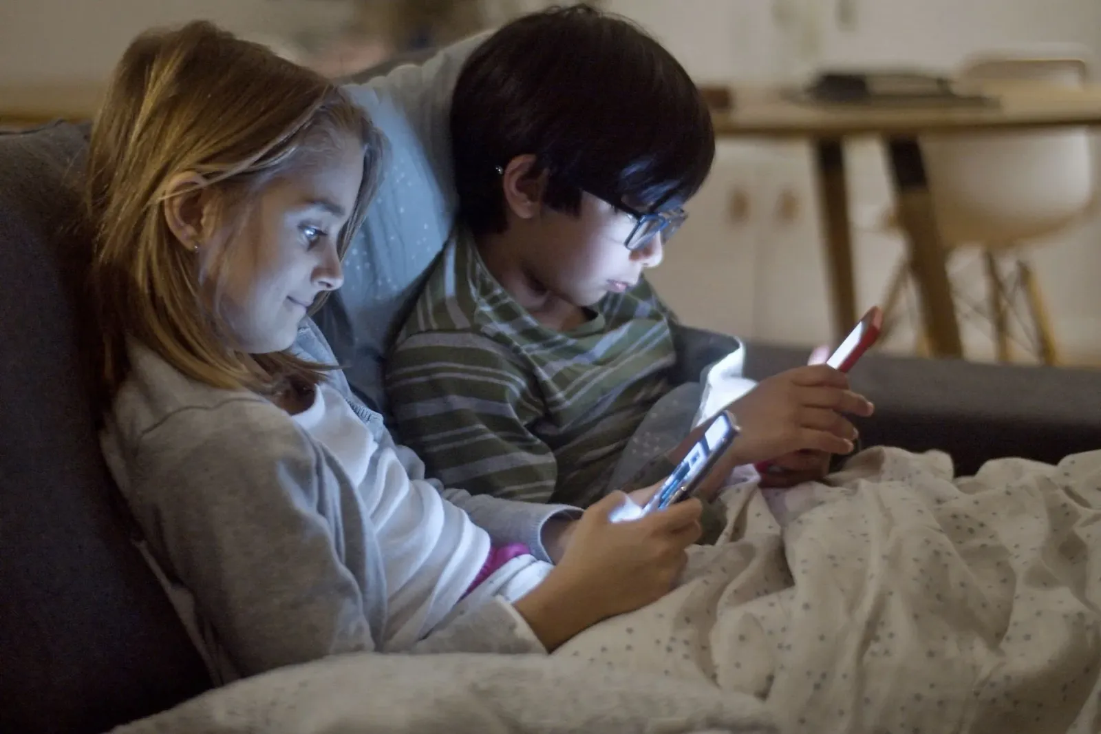Labarik kiak sira uza telemóvel no tablet iha sala ida, ho espesialista ida iha kotuk fó avizu kona-ba krísis uzu ekrã. Imaje