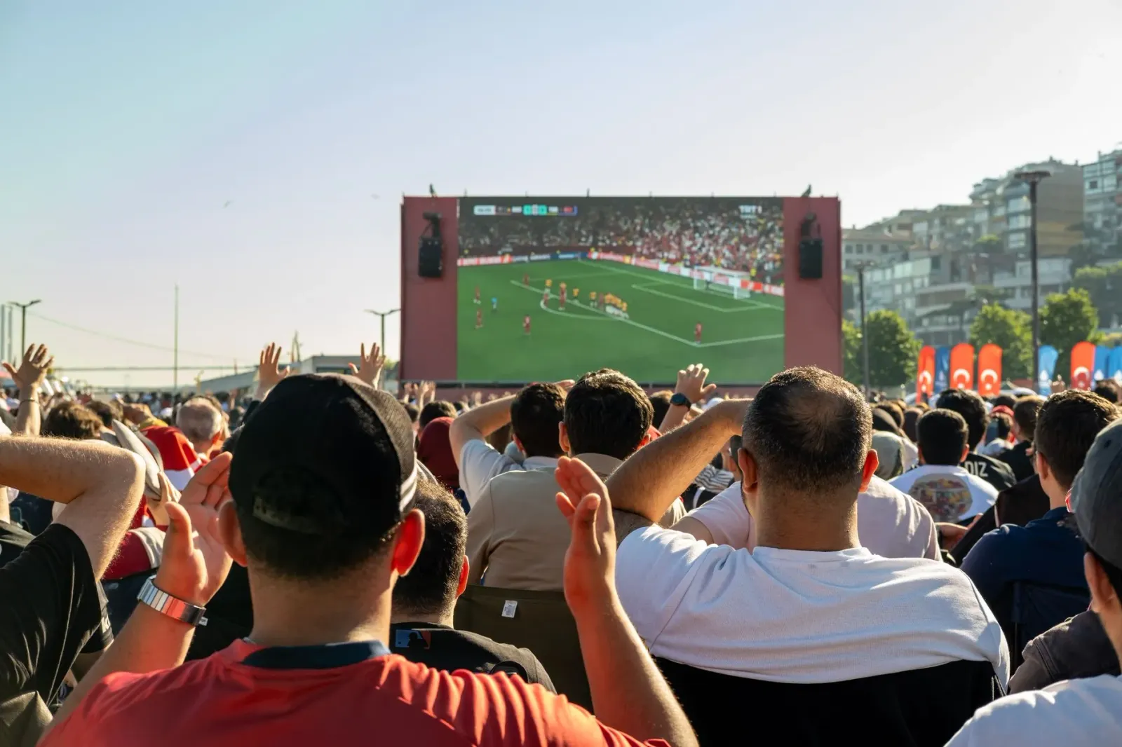 Imajen hatudu fã desportu sira iha estádiu, ho ema hentus no bandeira, hatudu atmosfera boot iha jogu NBA, AEW no World Cup