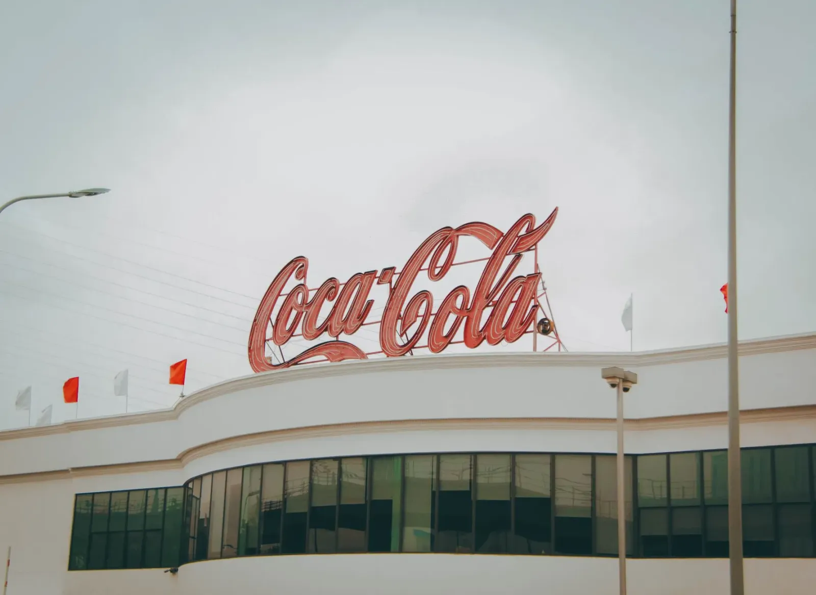 Imajen ilustrativu kona-ba akordu akuisisaun indeks, anúnsiu Coca-Cola, no tela programa John Oliver, hatudu oinsá média no n