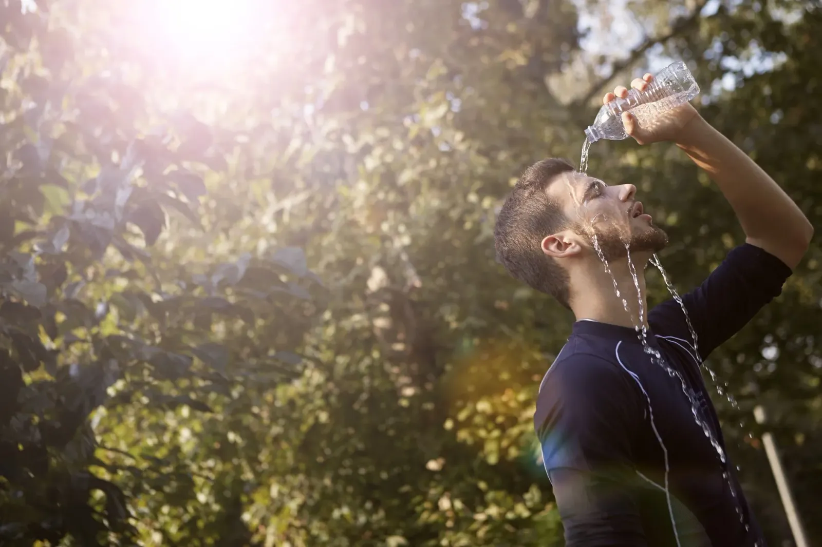 Imajen ida ne'ebé hatudu ema ida hemu bee iha tempu manas, ho sombra iha kotuk, atu prevene heatstroke.
