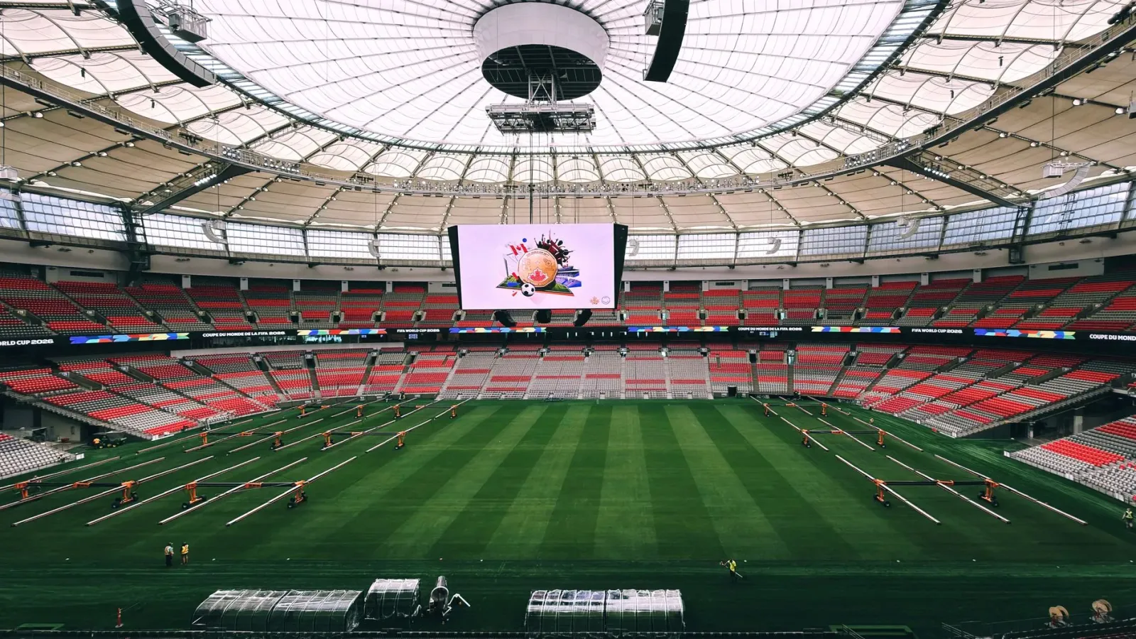 Fotografia husi jogu fuból Mundial 2026 entre Qatar no Canada iha estadiu, ho jogadór sira prepara atu komesa partida