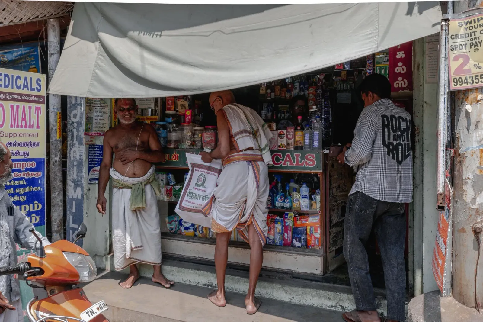 Imajen ida hatudu interior farmásia komunál iha Tamil Nadu ne'ebé seidauk iha kliente barak, ho prateleira medikamentu mamuk 