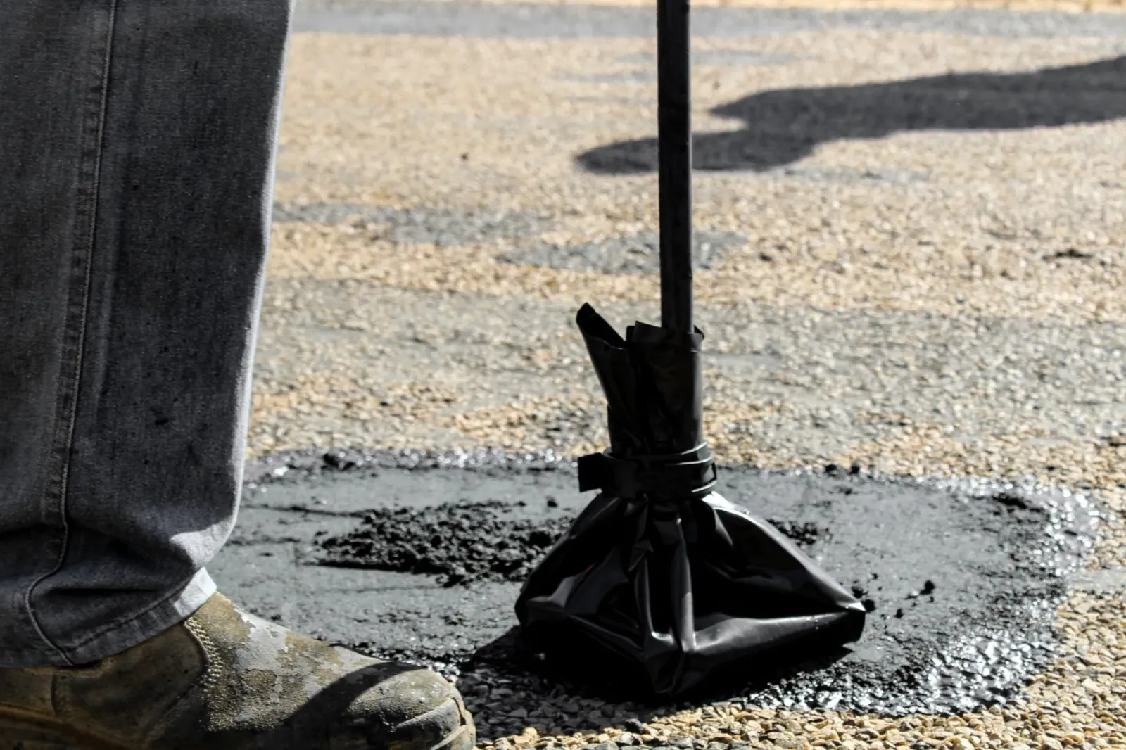 Imajen ida hatudu dalen estrada asfaltu ho pothole boot, iha laran iha sensór no drone ki'ik ne'ebé monitoriza, ho teknolojia
