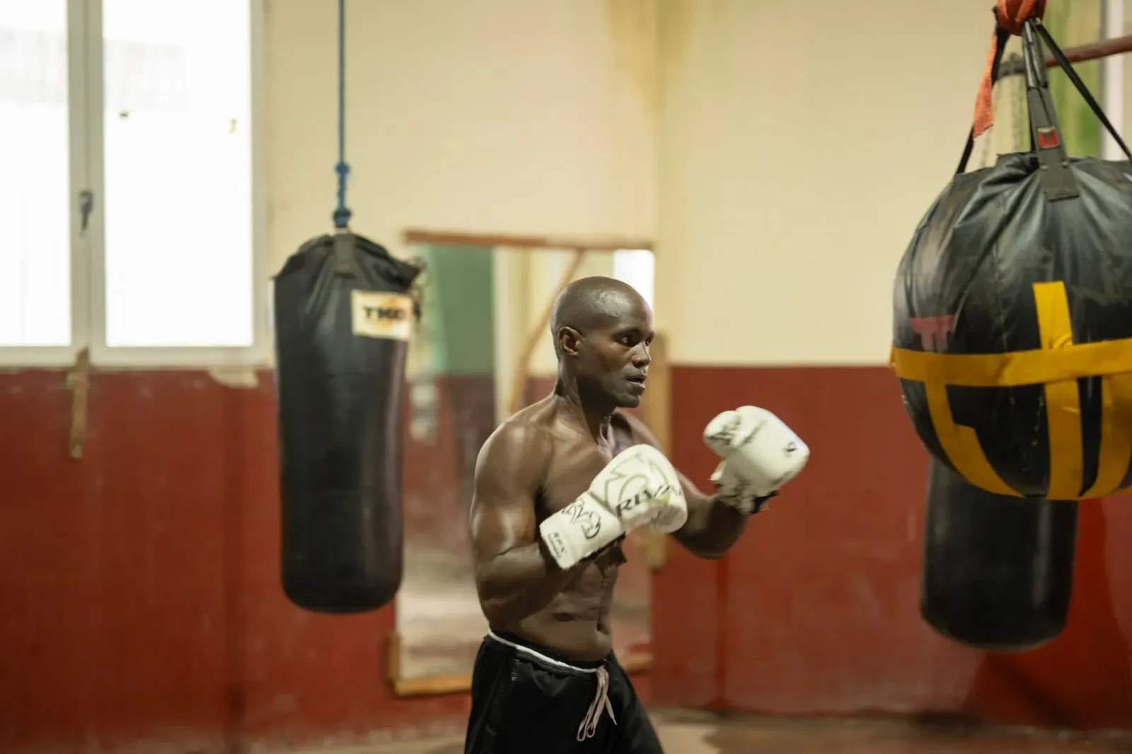 Floyd Mayweather iha ring boxe iha Las Vegas, ho ema barak iha background, nia hateke ba kâmara ho expresão sériu, hatudu kat