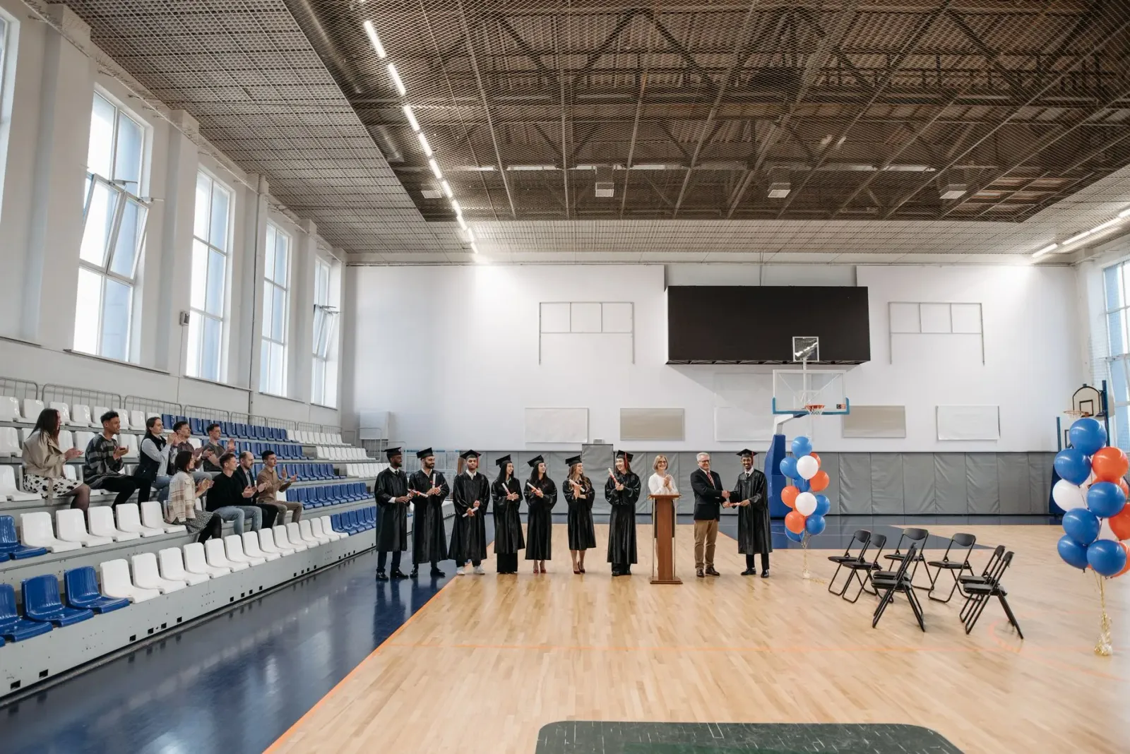 Estudante sira booing iha serimonia graduasaun bainhira oradór koalia kona-ba teknolojia AI. Sira hatudu ekspresaun laran kan