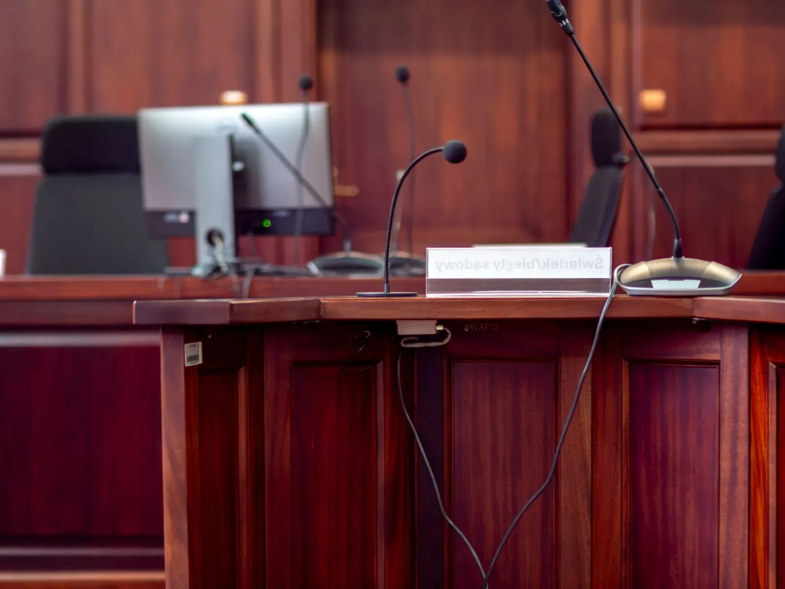 Imajen ida hatudu tribunal ho juiz no advogadu sira koalia kona-ba AI iha indústria entretenimentu, ho komputadór no dokument