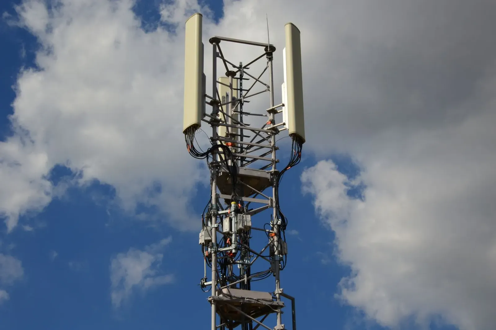 Imajen ne'ebé hatudu torre 4G iha área rural, smartphone ho AI, no ema sira uza teknolojia foun atu moris di'ak liu.