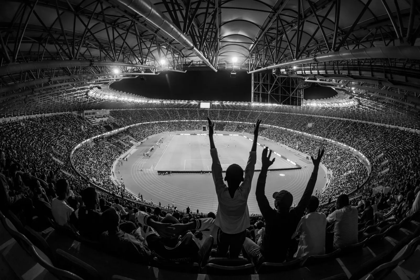 Atleta feto halai no hatudu emosaun alegria iha estadiu ho torcedór barak iha fundu, hanesan espresaun rai emosaun iha despor
