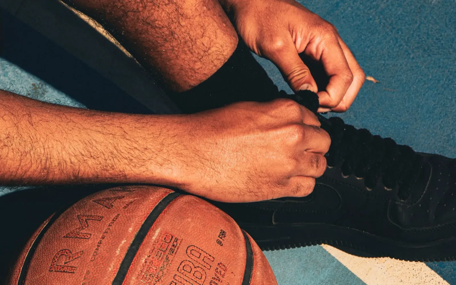 Jogadór NBA sira halai iha quadra ho torcedór barak iha fundu, ilustra kompetisaun boot iha liga profisionál.