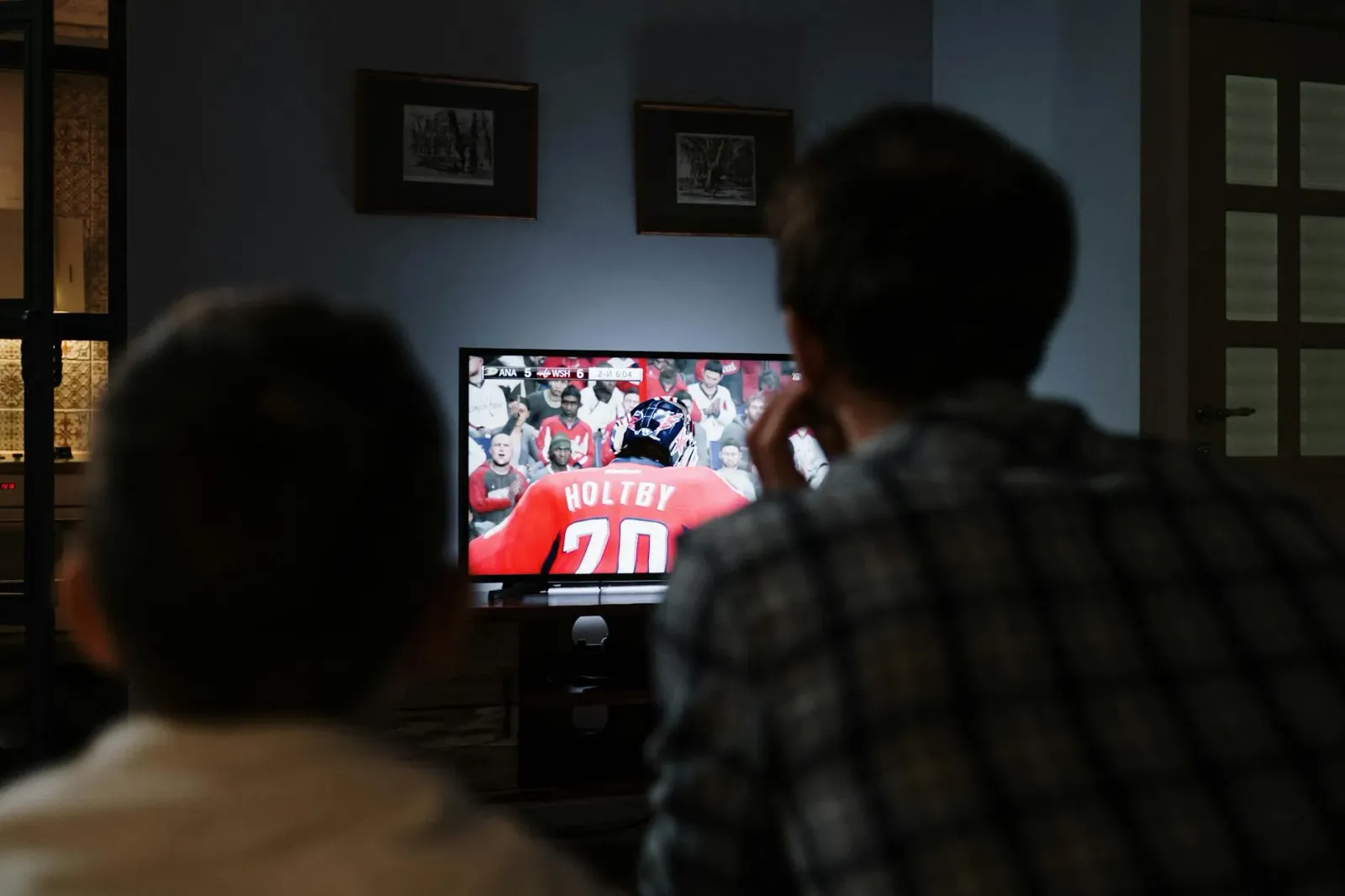 Ema ida tuur iha sala, haree jogu futebol iha TV Hisense U6SF MiniLED, ho imajen klaru no kor vibrante, hatudu esperiénsia pr