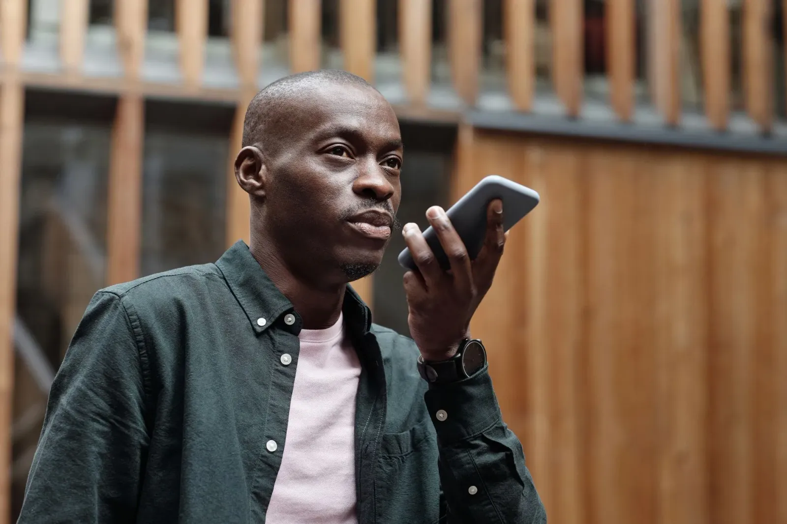 Ema ida uza smartphone ho funsaun asistente voz atu halo transkrisaun konversa iha tempu real, hanesan Jio Call Agent.