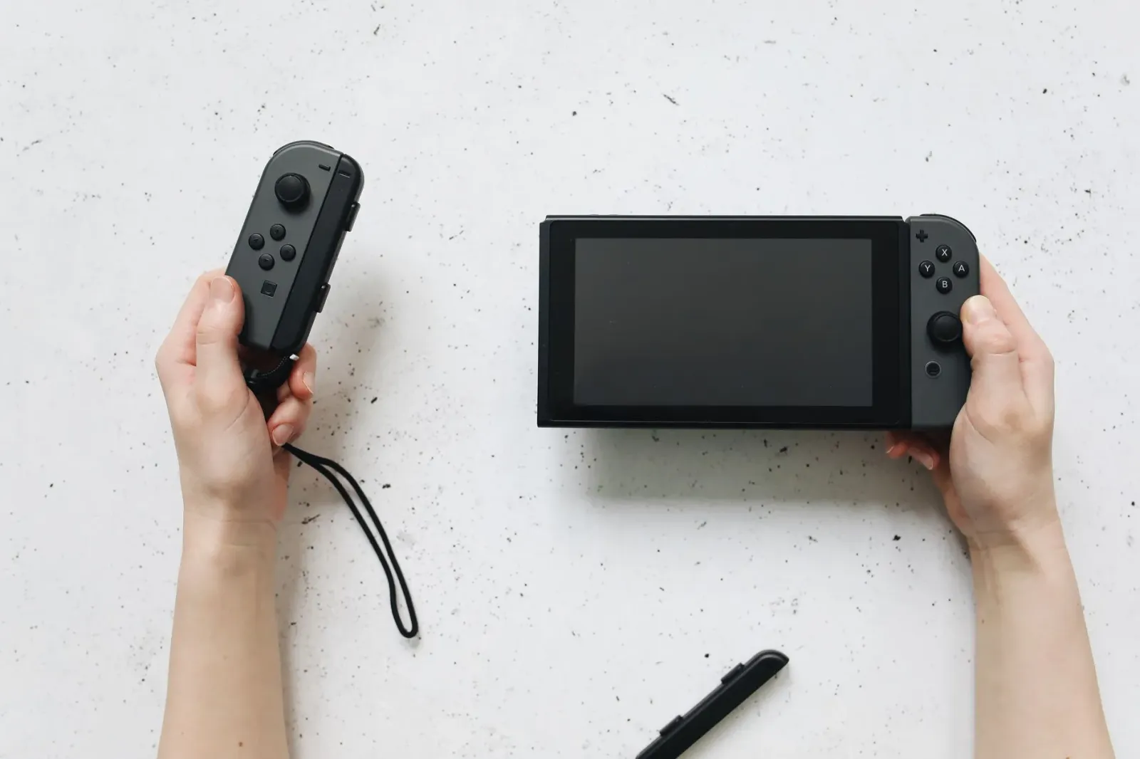 Imajen ida hatudu jogu Nintendo Switch Sports Resort ho jogadór sira uza Joy-Con 2 hodi joga tenis iha Wuhu Island.