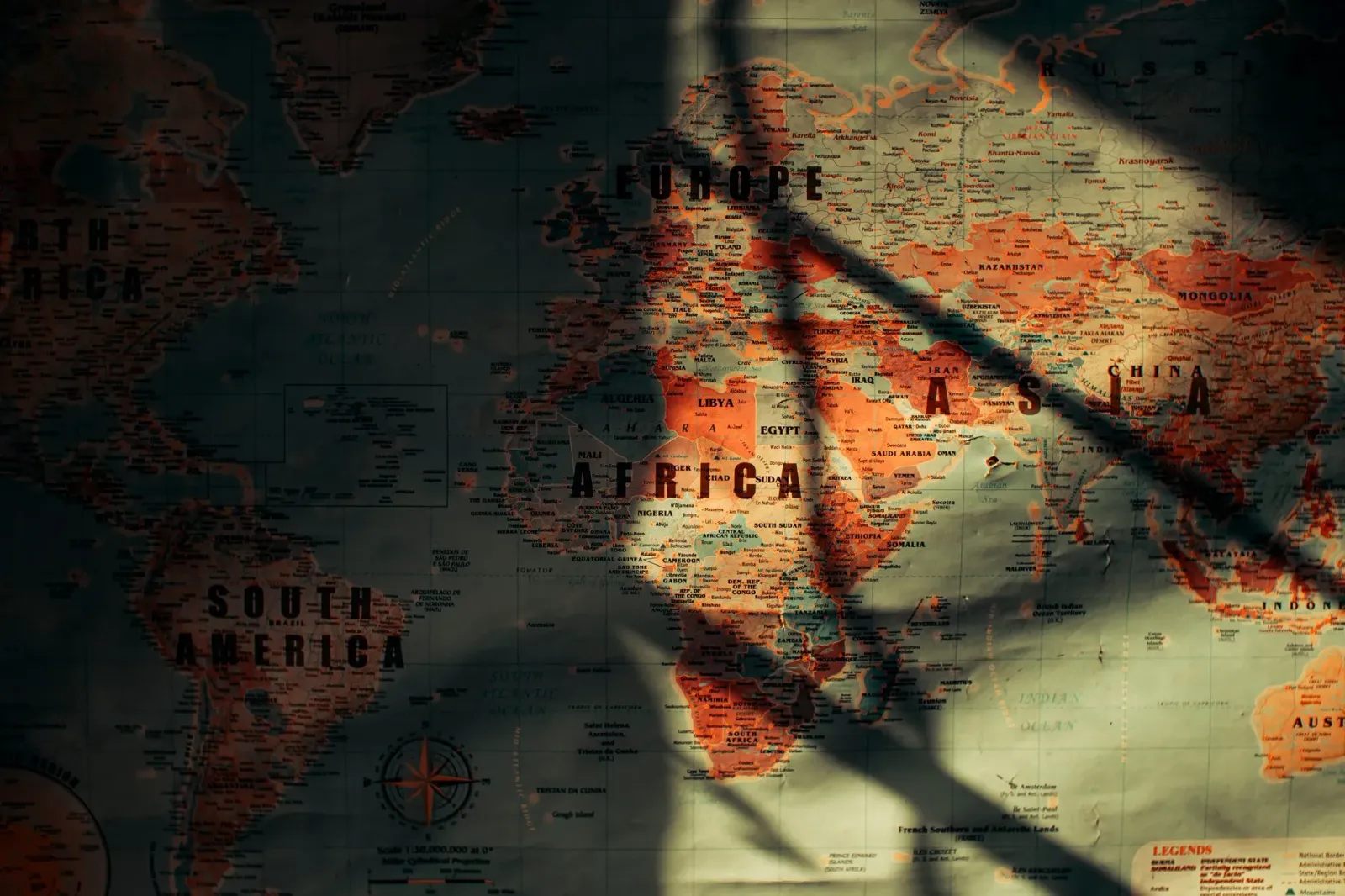Mapa mundu ne'ebé hatudu ligasaun entre merkadu finanseiru no tensaun geopolítiku, ho ikon negósiu no seta entre nasaun sira,