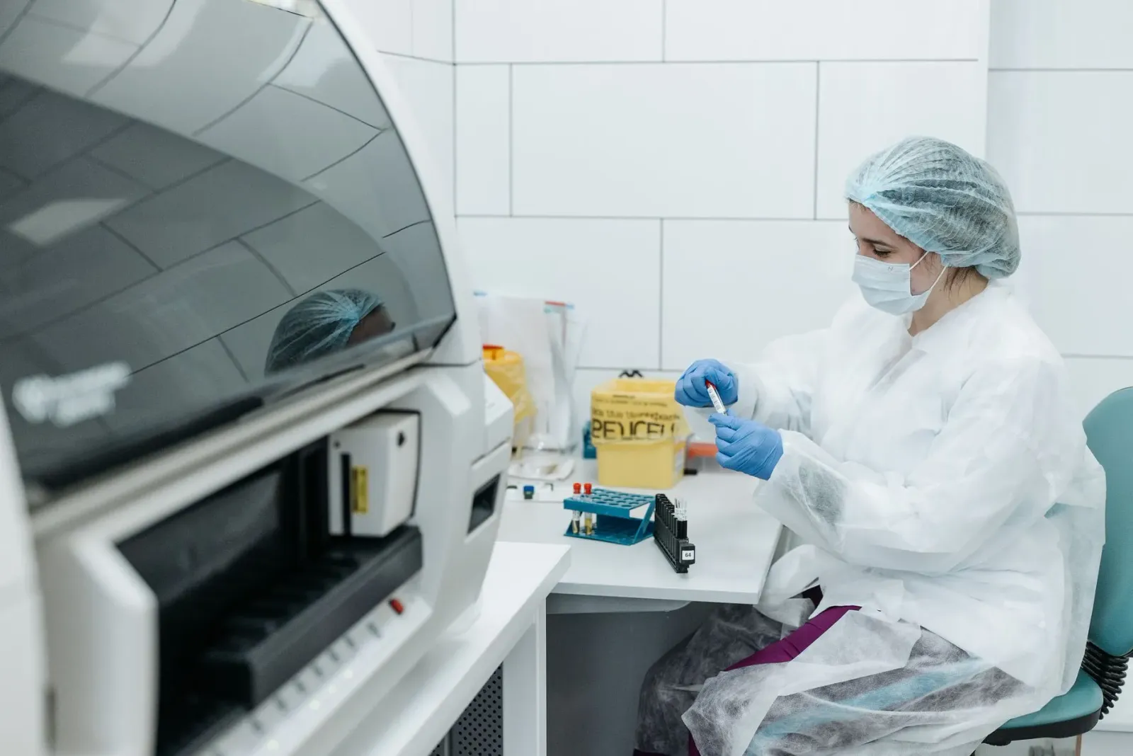 Sientista ida analiza dados genética iha laboratóriu, ho komputador no mikroskopiu iha meja