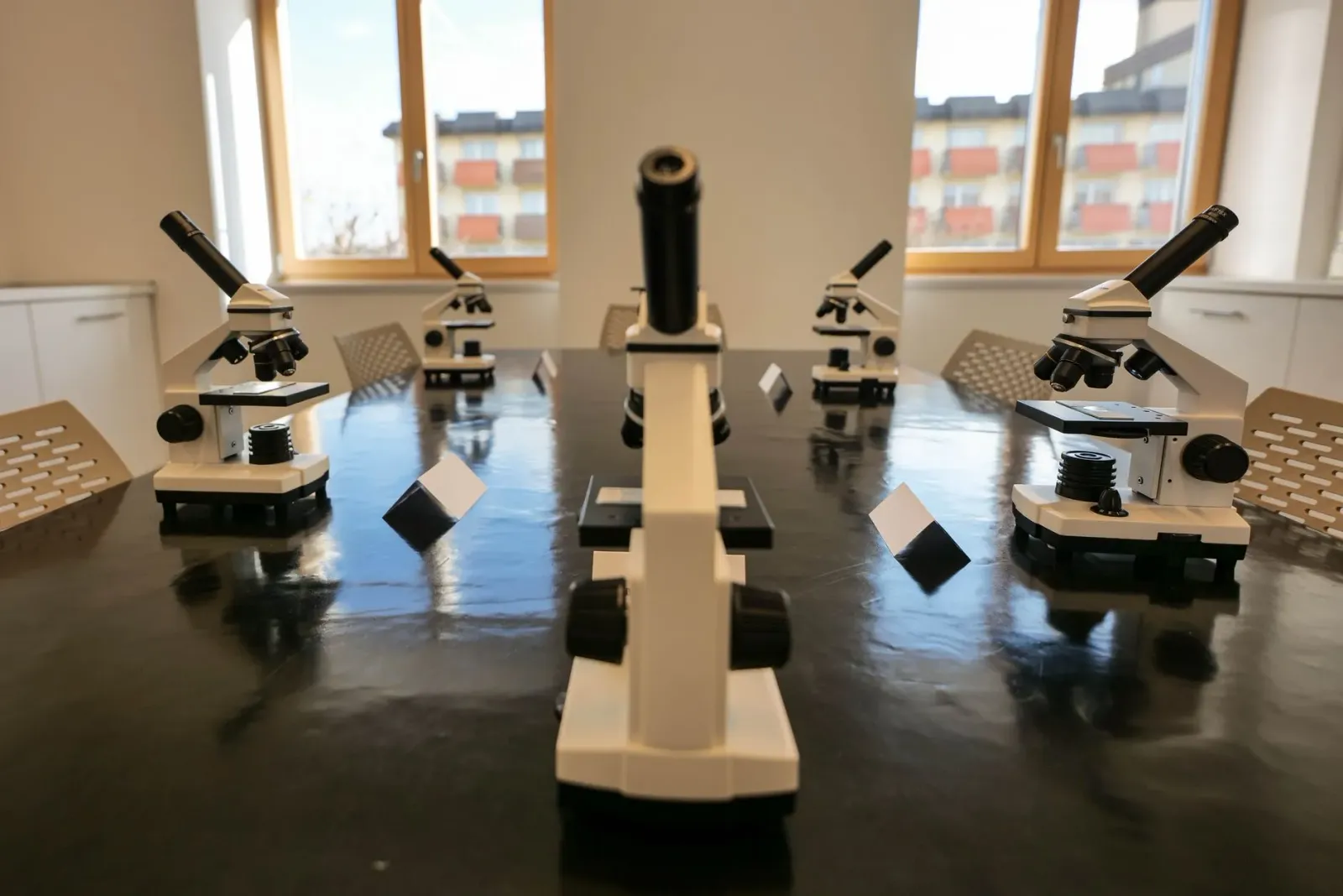 Imajen ida ne'ebé hatudu sientista sira servisu iha laboratóriu ho komputadór no ekipamentu sientístiku, refleta peskiza kona