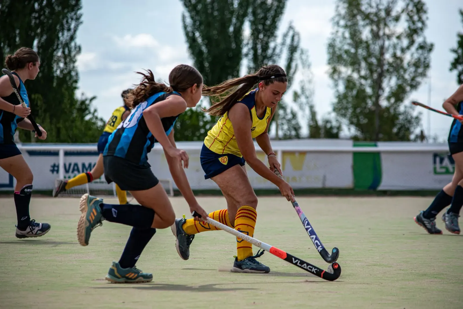 Imajen hatudu jogador hóquei sira kompeti iha torneiu memorial Arjan Singh iha Bengaluru, ho ekipa uniforme no stick hóquei i