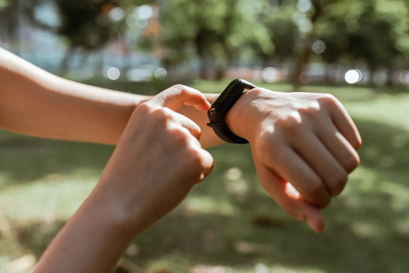 Atleta uza fitness tracker iha liman, hamutuk ho TV ne'ebé hatudu jogu futebol liuhusi Fire TV Stick, iha sala treinu