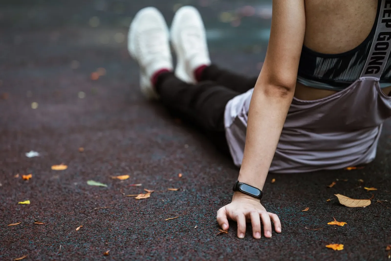 Atleta ida uza fitness tracker iha liman durante treinu, ho suor no background estadiu