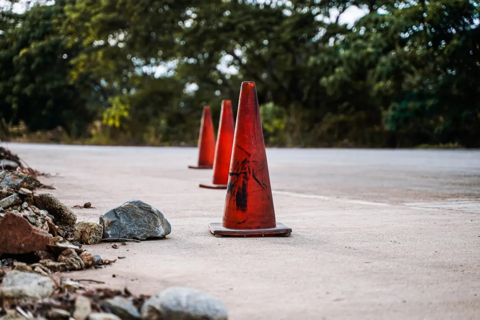 Imajen hatudu kona-ba parkir ilegal iha estrada nasionál ho tranzitu no cones laranja, hanesan ilustrasaun ba problema parkir