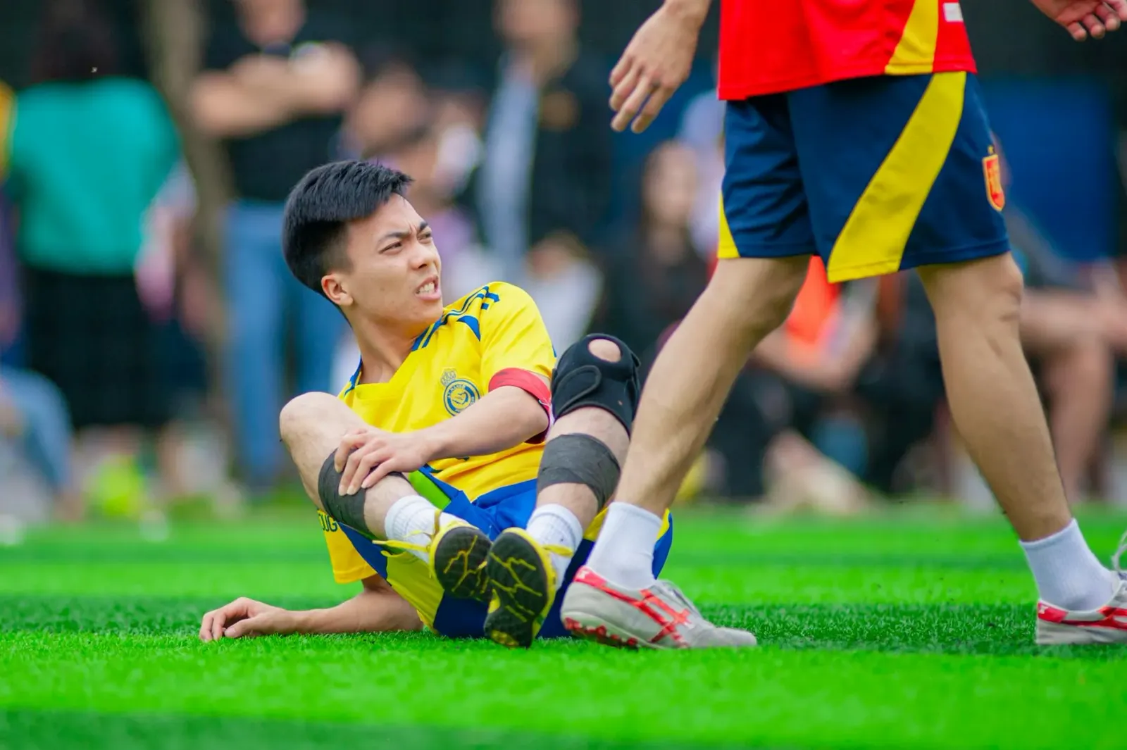 Imajen hatudu estadiu futebol ho televizaun boot iha tela, jogador NFL ho uniforme, no jogador baseball ho operasaun marka ih