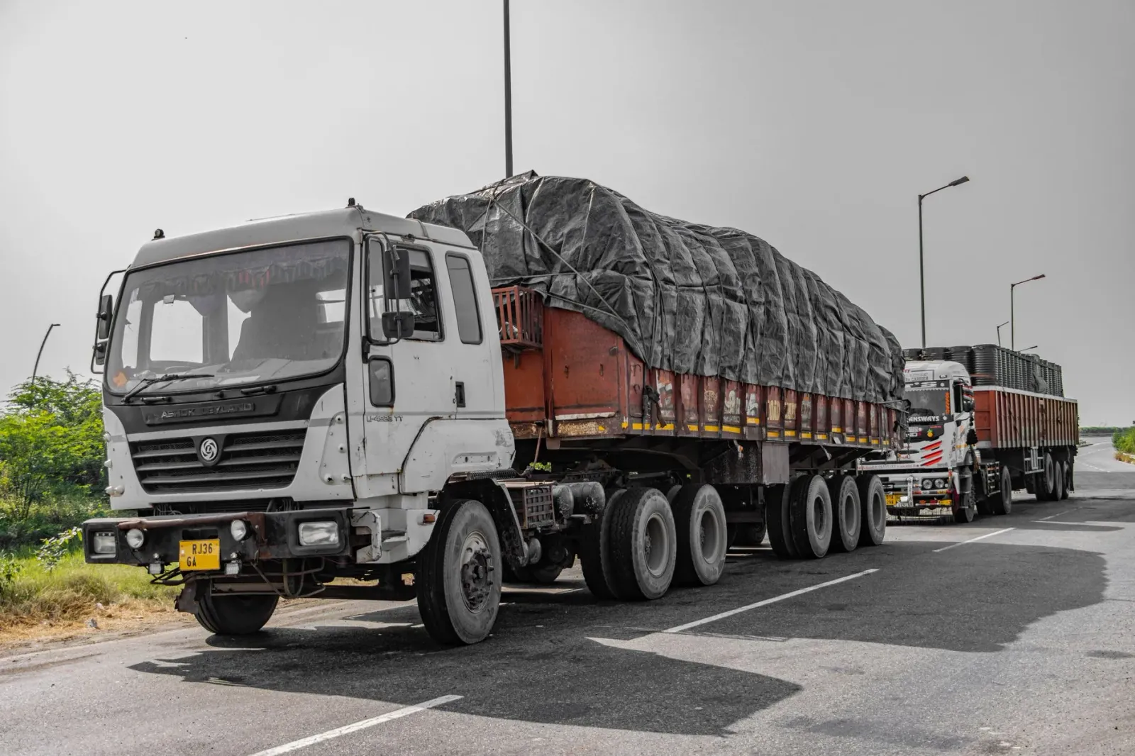 Imajen kareta kontentor ne'ebé ahi boot iha dalan Mumbai-Ahmedabad, ho fumaça boot no bombeiru sira servisu, iha Palghar, Índ