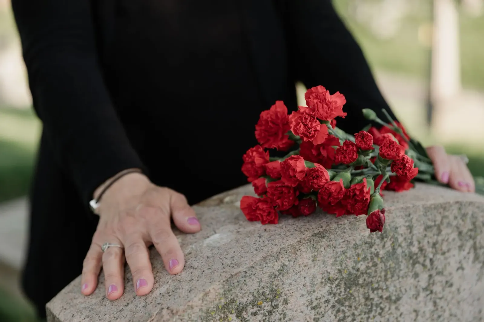 Imajen ida hatudu ema nia liman hodi klamar iha serimónia funerál, simboliza laran triste no hakotu lutu, hanesan istória Raj