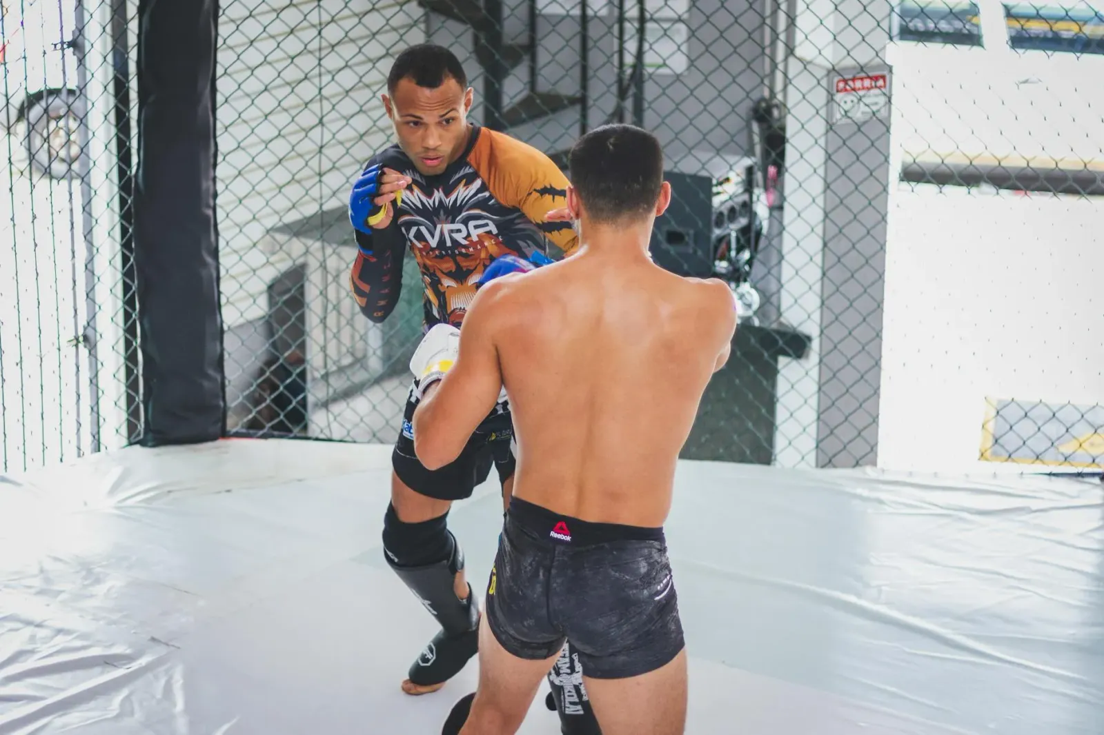 Imajen ida hatudu Darren Till iha luta bare knuckle BKFC, ho nia isin nakonu suar no fokus ba adversariu, iha ringue ho luz a