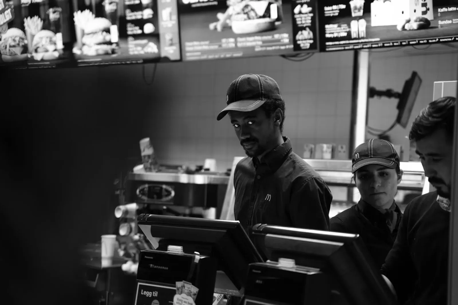 Imajen ida hatudu ema servisu iha restorante restoran lori hahan hosi lixu. Sira baku tiha hahan ne'ebé sei atu serve ba klie